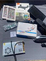 Full lot layout showing tablet box, cases, Airvue holder box, keyboard, remote, and silver electronic unit