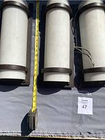 Three identical metal wall sconces painted in off-white and dark brown bands to imitate wood, shown with measuring tape indicating size.