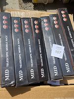 Seven boxed MID telescopic mobile racks stacked in a box outdoors.