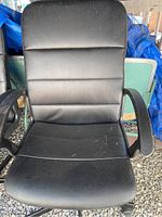 Front view of a black office chair showing the seat, backrest with horizontal stitching, and armrests.