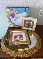 View of the six items together showing various framed chicken paintings and the round gold tone ornate wall mirror.