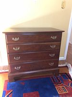 Front view of the Stickley wooden dresser with four drawers and metal pull handles, showing the overall design and condition.