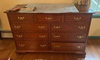 Full front view showing nine drawers and brass handles