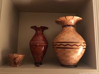 All three pieces displayed together on shelf: large vase, small vase, bowl