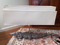 Front view of pewter alligator lamp on floor with double-tiered rectangular shade