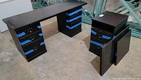 Full desk setup showing three storage cabinets with multiple drawers and three separate removable tabletops with blue tape securing drawers and table edges.