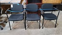 Front view of three black office guest chairs side by side