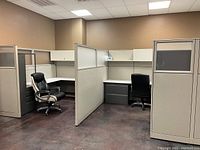 View of 7 interlocked office cubicles showing partition walls, two workstations with chairs and pedestal units.
