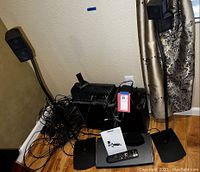 Two Bose satellite speakers mounted on black metal stands with cables running behind