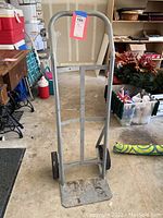 Full view of the metal hand truck showing frame, handle, and wheels.