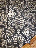 Close-up photo of the smaller throw rug with detailed view of floral geometric pattern and color scheme.
