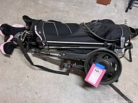 Full view of set with golf bag, clubs inside, and golf push cart