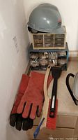 Overview of hardware storage units, hard hat on top, gloves and brushes in front