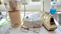 Oskar food processor, Krups can opener, and Waring hand mixer shown together on kitchen counter with power cords.