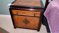 Front perspective showing overall design, black lacquer frame and natural wood inset top