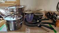 Overview of all cookware items including pots, pans, measuring cup and steamer insert