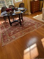 Overall view of hand-woven Oriental rug under dining table on hardwood floor