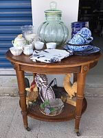 Full lot of glass cookie jar, ceramic kitchen items, rooster decorations, and kitchen towel arranged on wooden table.