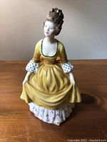 Front-view photo of Royal Doulton Coralie figurine showing detailed dress and face.