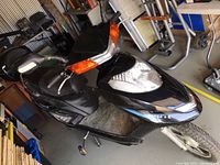 Three-quarter side view showing overall condition, model name on side panel, tires and body panels