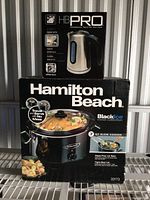 Front view of boxed Hamilton Beach Black Ice 7 QT slow cooker and HB PRO digital kettle stacked.