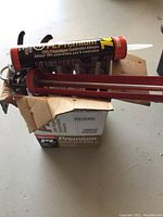 Photo of several tubes of Lepage PL Premium adhesive in an open cardboard box with red applicator guns.