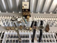 Overview of twelve wristwatches and pocket watches laid out