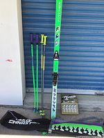 Complete lot including Fischer Vacuum skis, two pairs of ski poles (Rossignol and Scott), Pinnacle Gold ski wax kit, and Jake Dynasty ski bag.