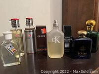 Group photo showing various perfume and cologne bottles including Swiss Army (two bottles), Gucci boxed bottle, frosted CK, black Chanel bottles, and Yardley Blazer.