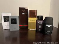 Six fragrance and aftershave bottles and boxes arranged side by side