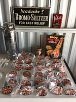 Overall shelf display of all items, including knobs, sign, tin, book, mug, and flask