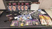 Full lot overview showing five boxed priest masks, multiple pairs of novelty fake nose glasses, Doctor's Mirror props, toy surgical scissors, and fake hanging bones on white display table.