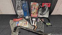 Full lot of costume accessories arranged on a black cloth background showing toy weapons, headbands, glasses, and other accessories.