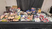 Wide shot of entire costume accessories lot laid out on table showing variety of ears, scars, finger props, nails, eyelashes, and teeth packages.
