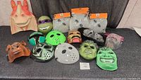 Wide view showing all masks including character and horror-themed masks on a black surface.