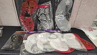 Multiple sets of fairy and butterfly wings displayed on a surface, including ladybug, silver, white, and black and white designs, all in original packaging.