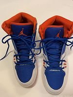 Top front view showing blue mesh fabric, orange padded collars, black laces and red Jumpman logo on tongue.