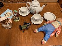 Wide view of the assorted Beatrix Potter themed items and Royal Doulton Bunnykins rabbit figurine on wood table
