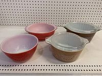 All four Pyrex bowls displayed together showing two mixing bowls and two casserole bowls with lids.