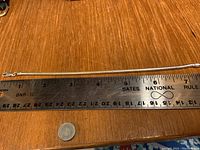 Full length photo of the silver snake chain bracelet alongside ruler measures about 7.5 inches.