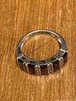 Close-up image of the sterling silver ring showing the five rectangular red stones set on the band.