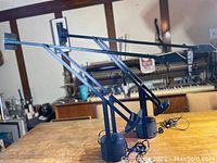 Two Tizio lamps side view on wooden table with workshop background