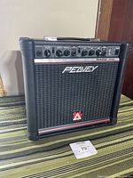 Front view of Peavey Rage 158 guitar amplifier showing control panel and speaker grille with Peavey and Rage 158 branding.