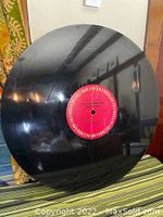 Photo showing the full 34-inch oversized black vinyl record display with a red Columbia Records label in the center.