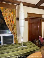 Front view of entire floor lamp showing fiberglass shade and metal base