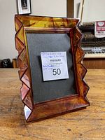 Front view of the clear amber picture frame with geometric wavy edges and a label showing size and brand.