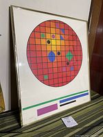 Framed screen print with circular geometric color design in red grid background