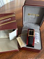 Photo of Citizen watch inside its official box showing the watch, instruction manual, and tag.