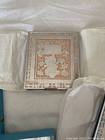 Pink Birks baby photo album in original wrapping, showing embossed silver-tone cover with teddy bear and floral design on pink background