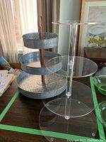 Photo showing both tiered serving stands side by side on a table, acrylic one on the right, metal on the left.
